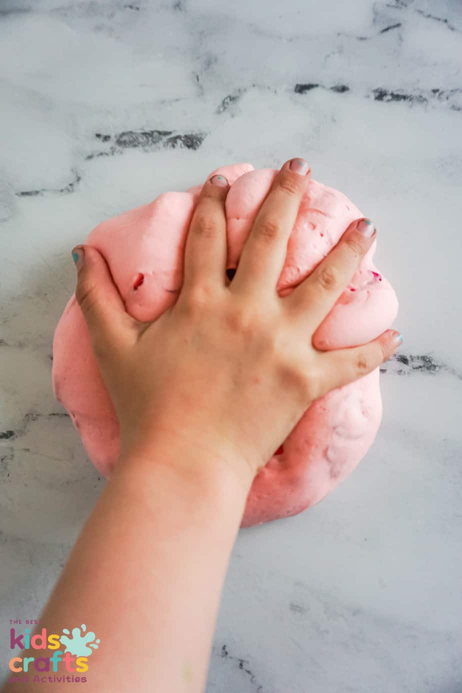 kids hand playing with Easy butter slime recipe for Valentine's Day